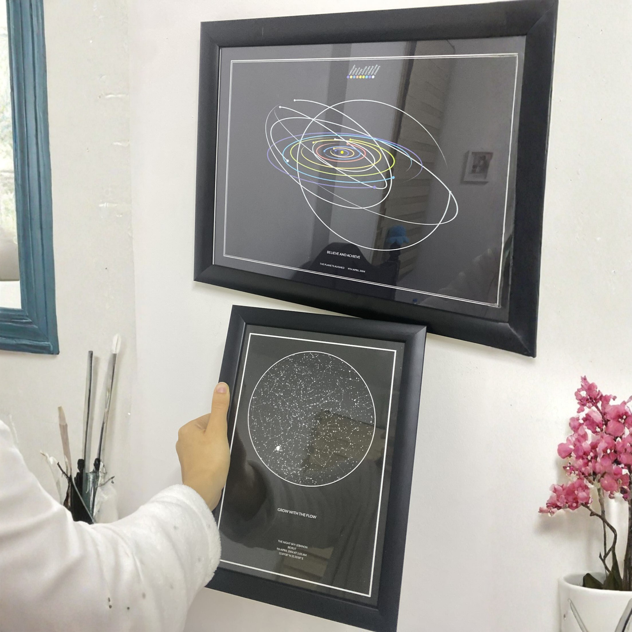 A girl holding a star map in front of an already hung up solar map.