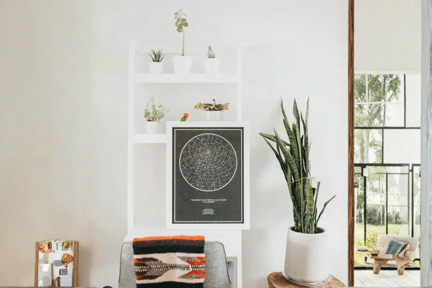 Personalized star map wall art in a modern living room with plants and minimalist decor
